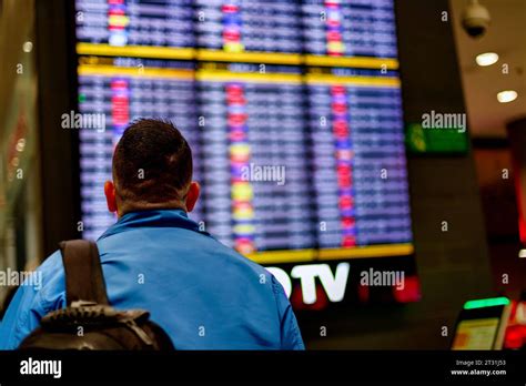 Passenger checks his flight in front of the arrivals and departures ...