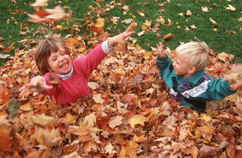 Two Children Playing In Fall Leaves Editorial Stock Image - Image: 23149739