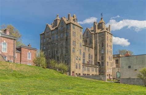 an old castle like building sitting on top of a lush green hillside