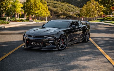 a black chevrolet camaro is parked on the street