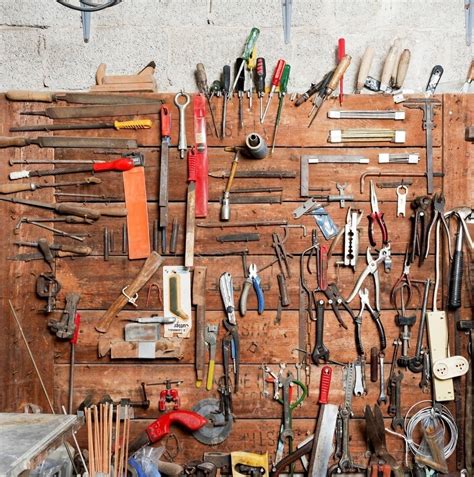 Variety of hand tools displayed on workshop wall - Stock Photo - Dissolve