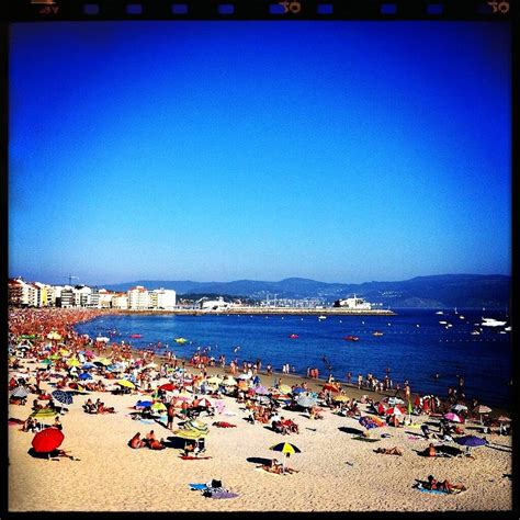 many people are on the beach with umbrellas