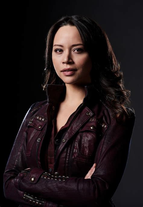 a woman in a leather jacket is posing for a photo with her arms crossed and looking at the camera