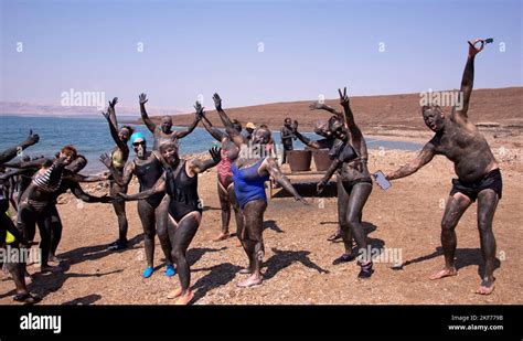 Group of people covered in mud Dead Sea Jordan Stock Photo - Alamy