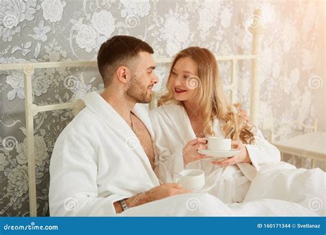 Romantic Couple in Bed Holding Cup of Coffee and Enjoy Honeymoon Morning on the Bed Stock Photo ...