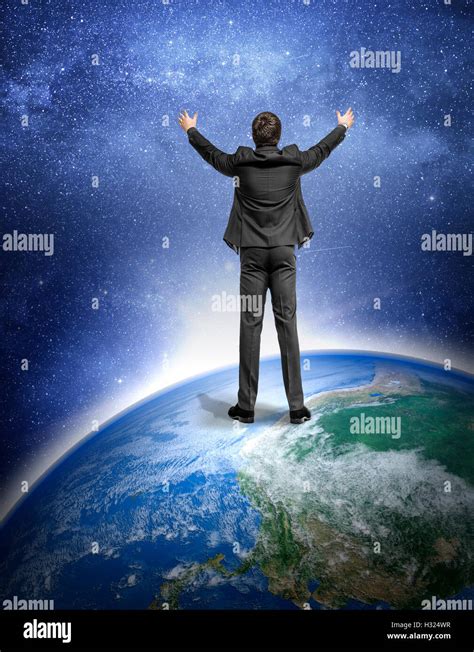 Man in a suit standing on the Earth planet and on the background of the night sky. Science ...