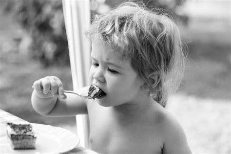 Premium Photo | Baby eating cake funny cute little boy eat sweet cake child eating dessert with ...