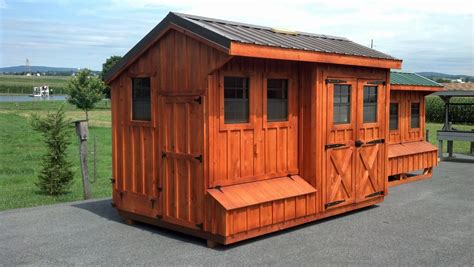 a small wooden building sitting on top of a parking lot next to a green field