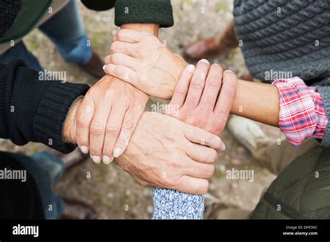 Four people touching hands, high angle Stock Photo - Alamy