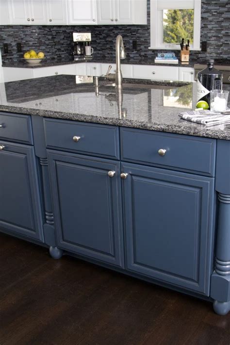 a kitchen with blue cabinets and granite counter tops on dark wood ...