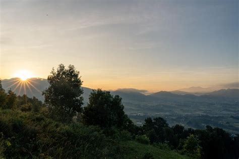 Premium Photo | A sunset view of the mountains from the top of the hill.