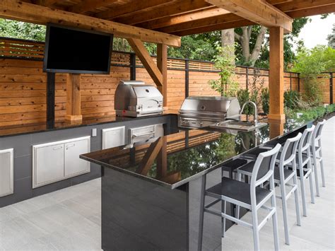 an outdoor kitchen with stainless steel appliances and bar stools