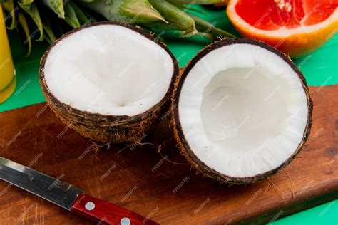 Free Photo | Close-up view of half cut coconut and knife on cutting board with other citrus ...