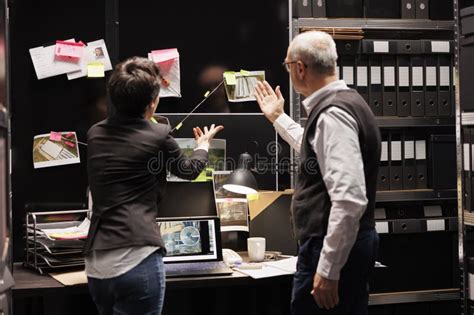 Police Officers Analyzing Board with Crime Scene Evidence Stock Image ...