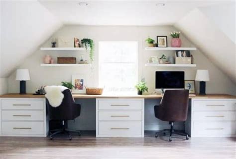 an attic office with two desks and chairs