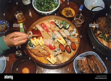 Using chopsticks to eat sushi and variety of Japanese foods Stock Photo - Alamy