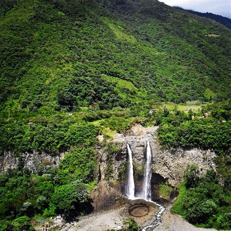 a large waterfall surrounded by lush green mountains