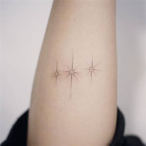 Fine line style stars on the forearm.