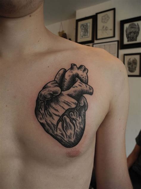 Black anatomical heart tattoo on the chest - Tattoogrid.net