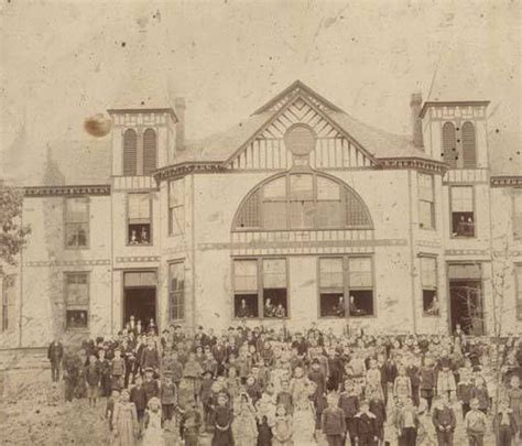 an old black and white photo of people in front of a building