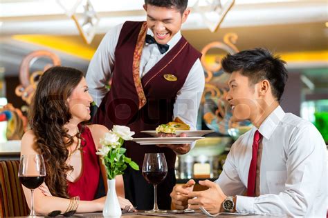 Chinese waiter serving dinner in elegant restaurant or Hotel | Stock image | Colourbox