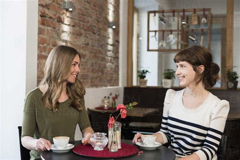 Two best friends sitting in a coffee shop stock photo