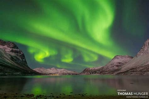 the aurora bore is shining brightly in the night sky over mountains and ...