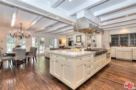 An open concept kitchen offers white cabinetry and a matching center ...
