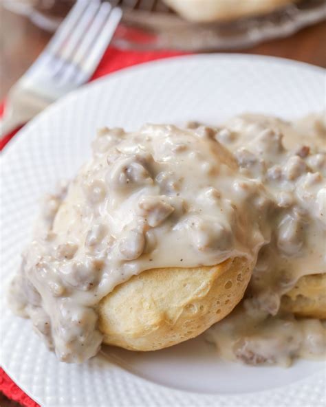 a white plate topped with biscuits covered in gravy