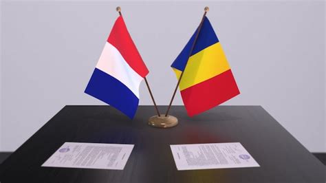 Premium Photo | Romania and france national flags on table in ...