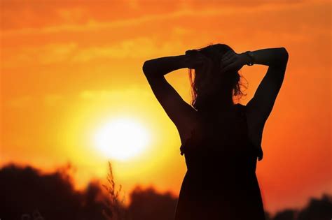 Premium Photo | Silhouette of a girl against the backdrop of a sunset.