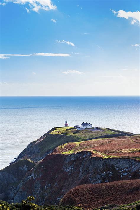 View of the trails on Howth Cliffs with the lighthouse in Irelan ...