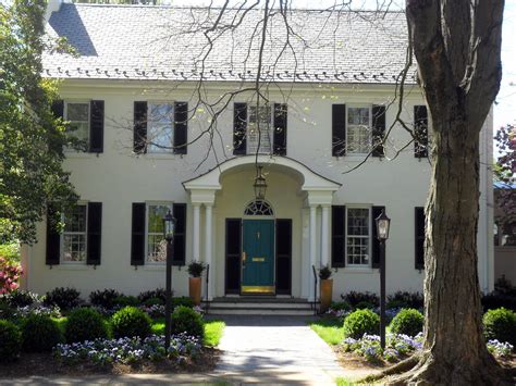 Classic White House with Black Shutters and a Pretty Painted Door