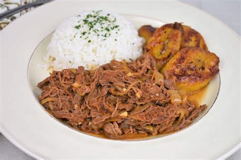 Ropa Vieja served with white rice and fried sweet plantains served on a ...