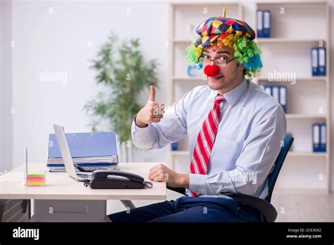 Funny employee clown working in the office room Stock Photo - Alamy