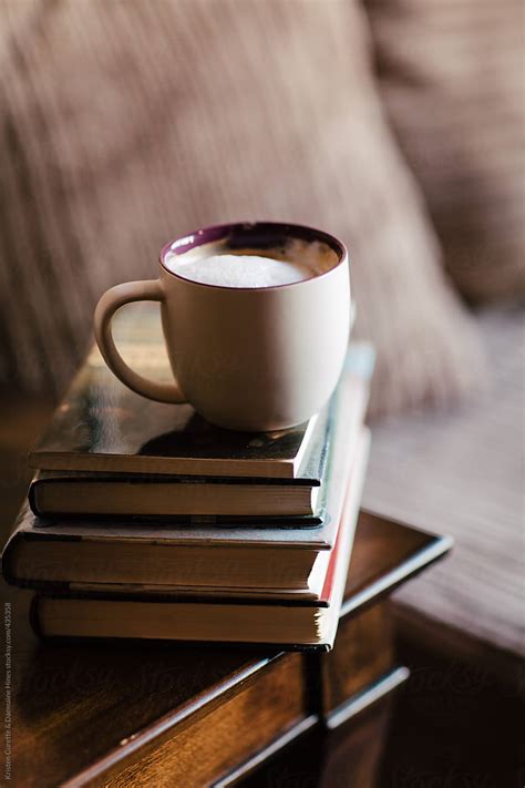 "Coffee On A Stack Of Books." by Stocksy Contributor "Kristen Curette & Daemaine Hines" - Stocksy