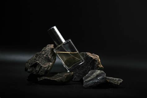 Premium Photo | Perfume on a stone on a dark background