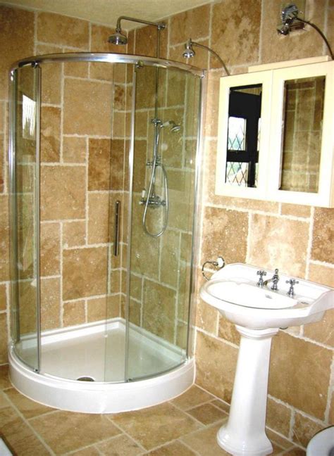 a white sink sitting next to a shower in a bathroom under a window on top of a tiled wall