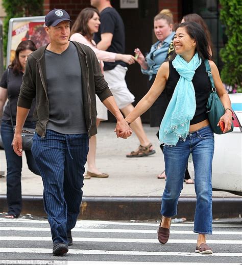 Woody Harrelson grins as he walks hand in hand with his wife Laura ...