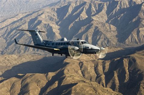 An USAF MC-12 Liberty comms/ELINT aircraft flies over mountains on a ...