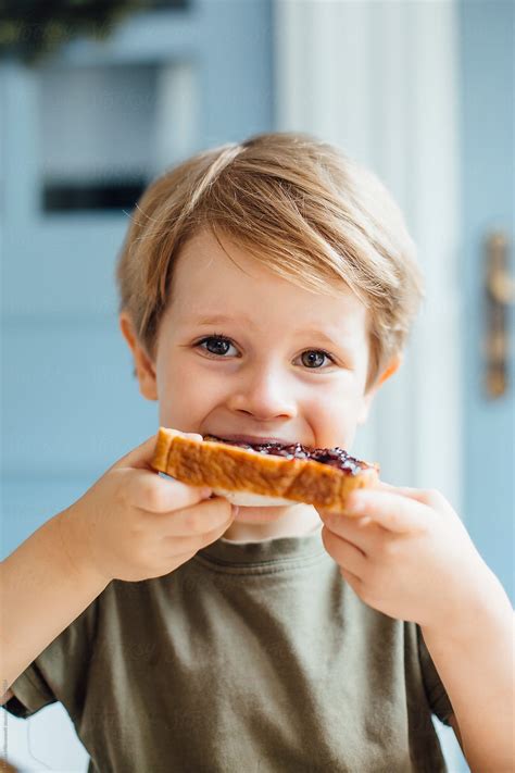 "Young Boy Eating Toast With Jam For Breakfast" by Stocksy Contributor "Marko" - Stocksy