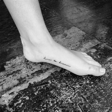 "Dare to dream" tattoo on the left foot.