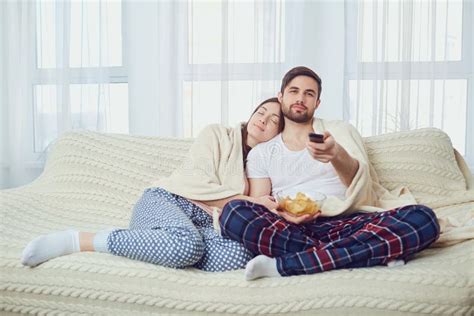 A Couple Watching TV Sitting on the Couch in the Room Stock Image ...