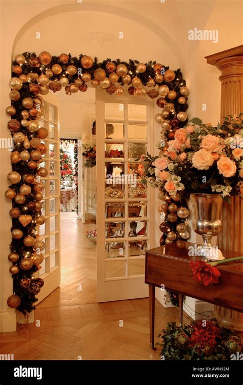 Living-room doorway decorated with Christmas garland and vase filled ...