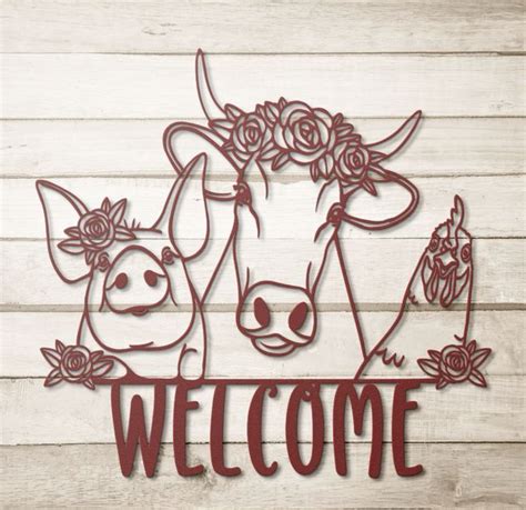 a metal sign that says welcome with two cows and roses on it, against a ...