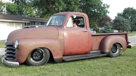 an old truck is parked in the grass