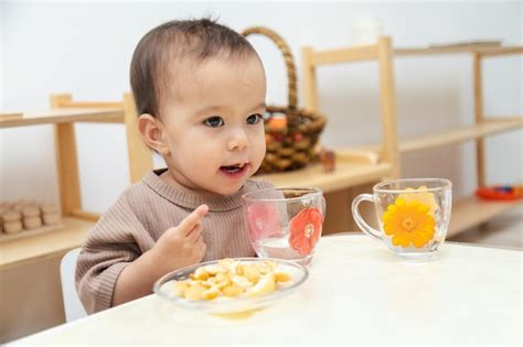 Premium Photo | Toddler eating snacks by table