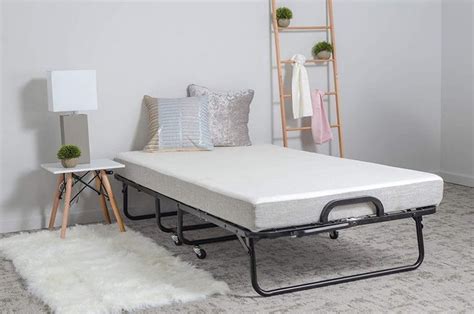 a bed with a mattress on top of it in a room next to a shelf