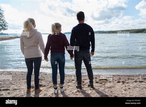 A family at the beach holding hands Stock Photo - Alamy