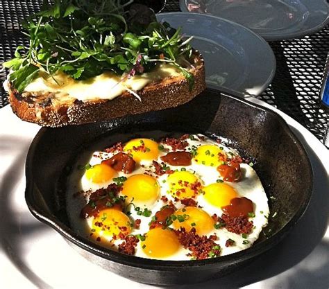 Quail eggs with house hot sauce, scallions, and bacon bits, and white lardo cheese toast topped ...